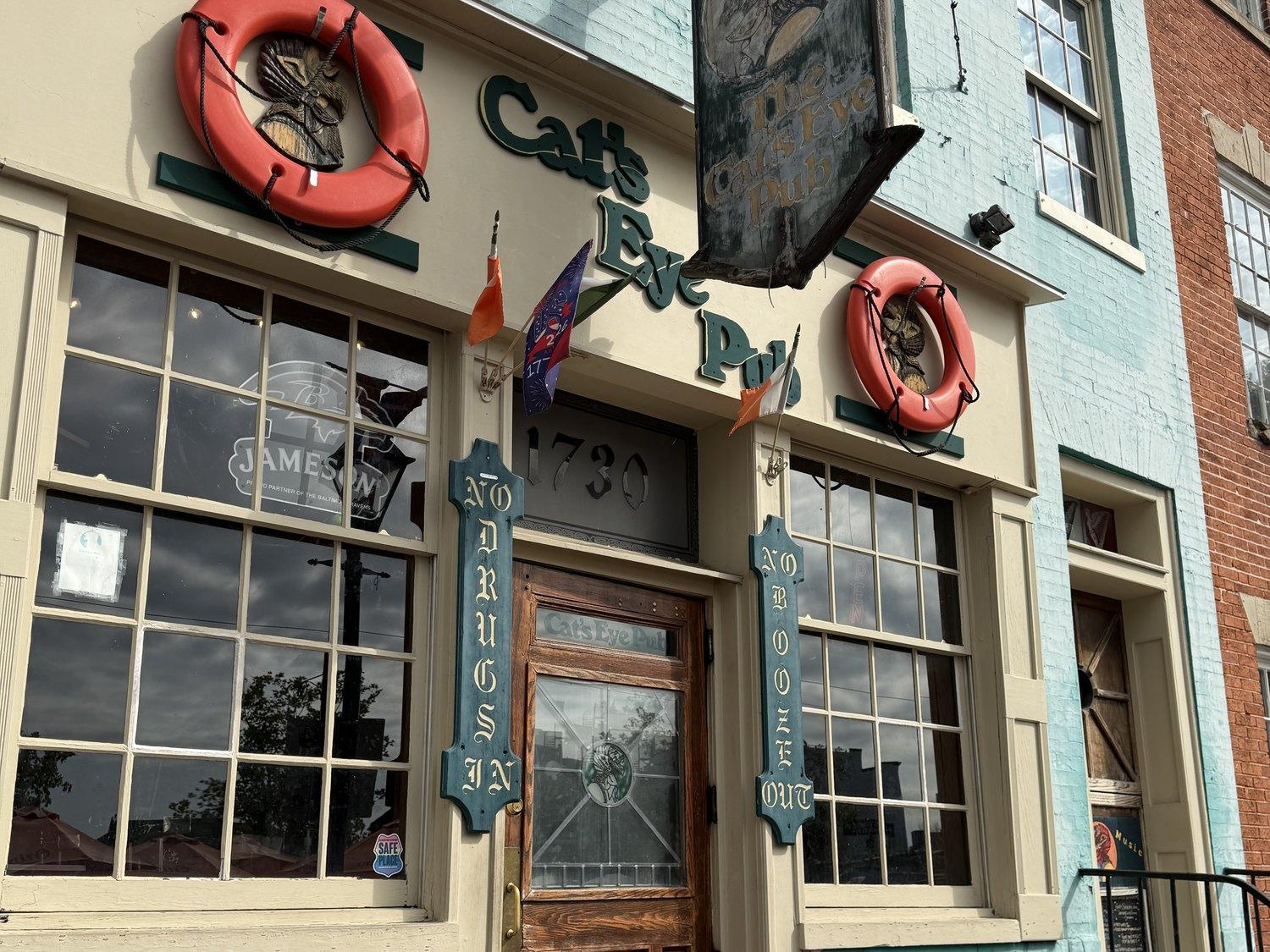 The Cat's Eye Pub's painted name and life rings above the door at 1730 Thames Street