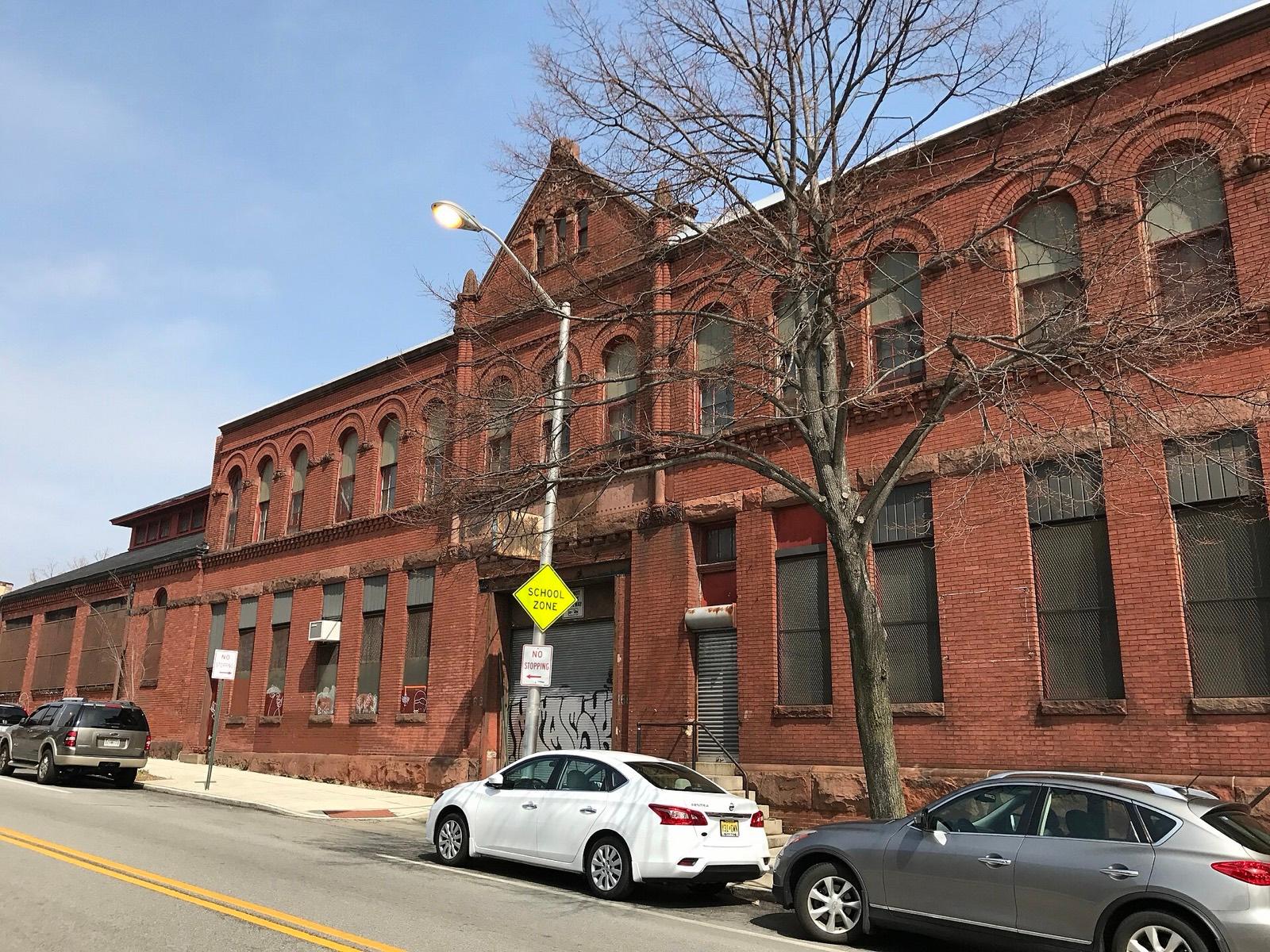 The former Crown Cork & Seal building at 1611 Guilford Avenue, a long brick block with arched windows, photographed in 2017 before Guilford Hall Brewery opened in it