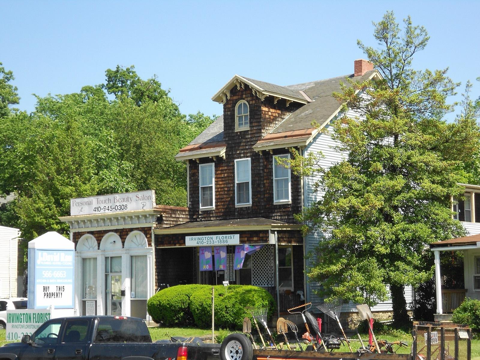 Frederick Avenue in Irvington: a shingled Victorian house over a shopfront, trees either side