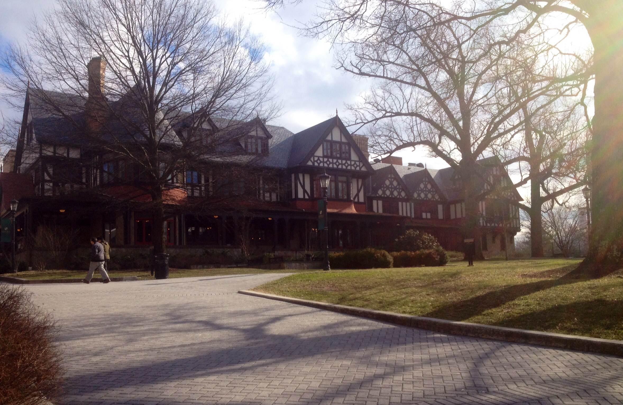 The Humanities Center at Loyola University Maryland, a Tudor-style mansion behind bare trees and a brick path, photographed in winter