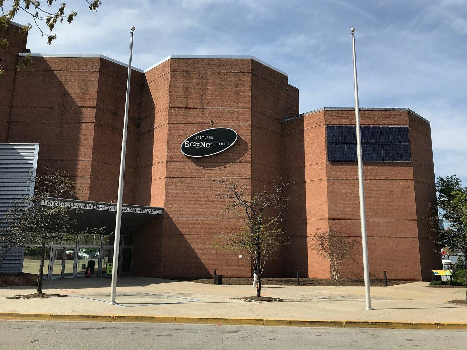The Maryland Science Center's brick and concrete entrance on Light Street, flagpoles out front