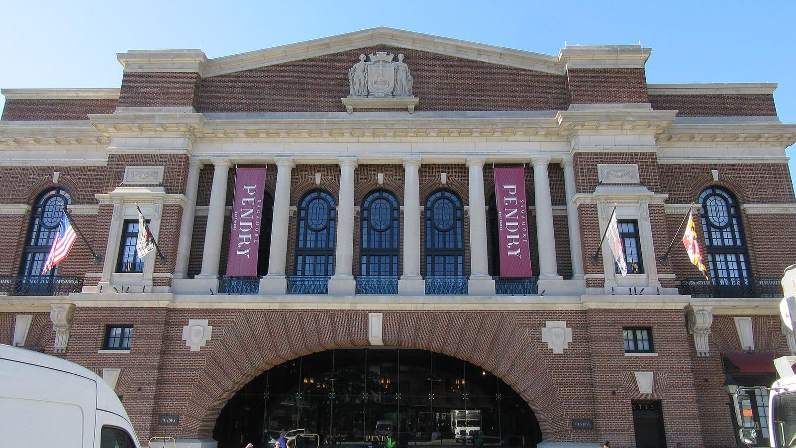 The Recreation Pier's brick and limestone front on Thames Street, Pendry banners between its columns