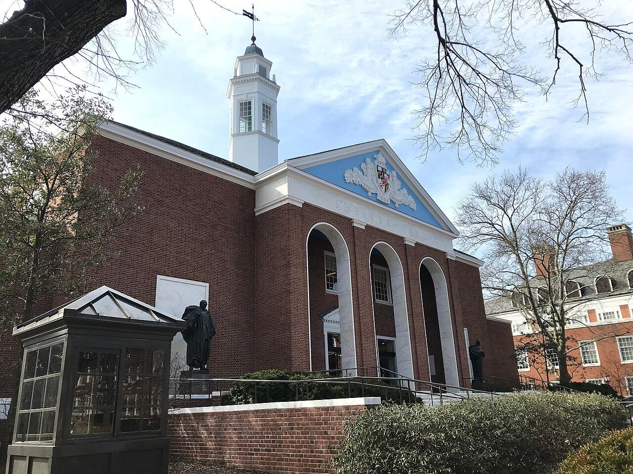 Shriver Hall on the Johns Hopkins Homewood campus, red brick with tall arched windows, a white cupola and a painted pediment