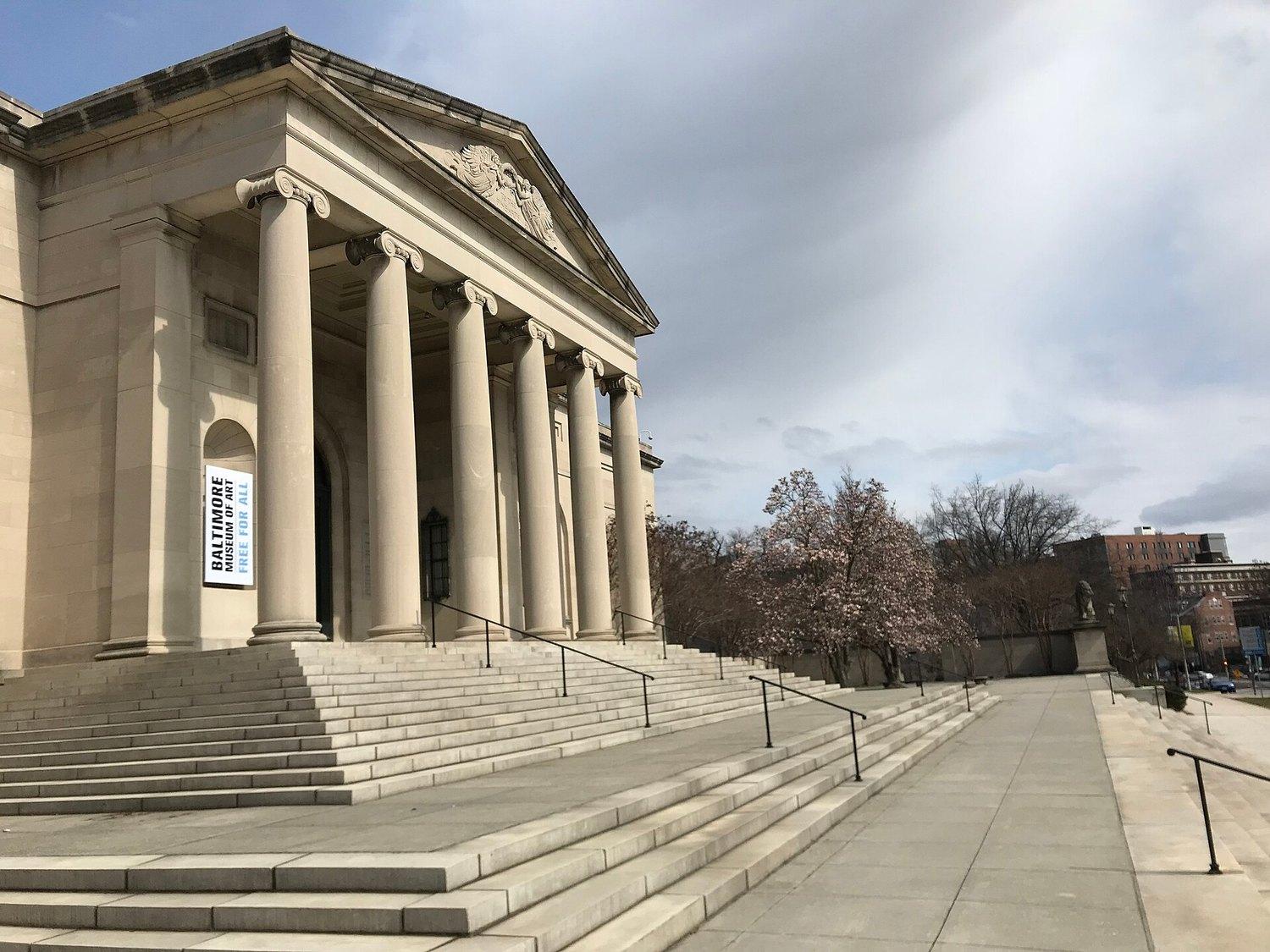 The Baltimore Museum of Art's columned portico and its flight of steps, a banner with the museum's name hanging between the columns