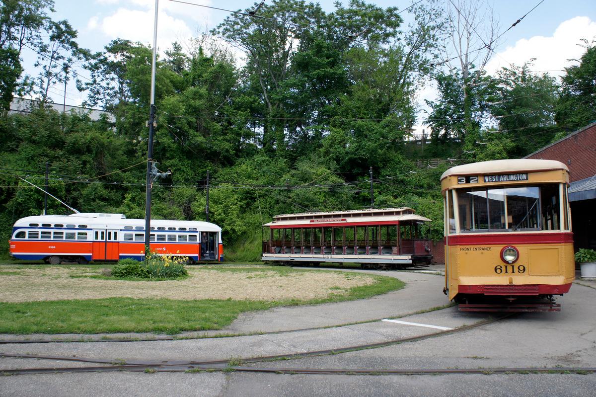 Restored Baltimore streetcars on the loop at the Baltimore Streetcar Museum on Falls Road, trees behind