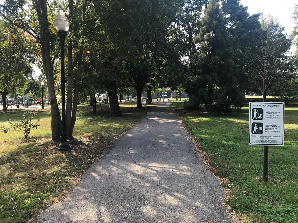 A tree-lined path through Latrobe Park toward the ball field and playground
