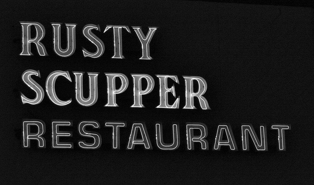 The Rusty Scupper's lit restaurant sign above Key Highway