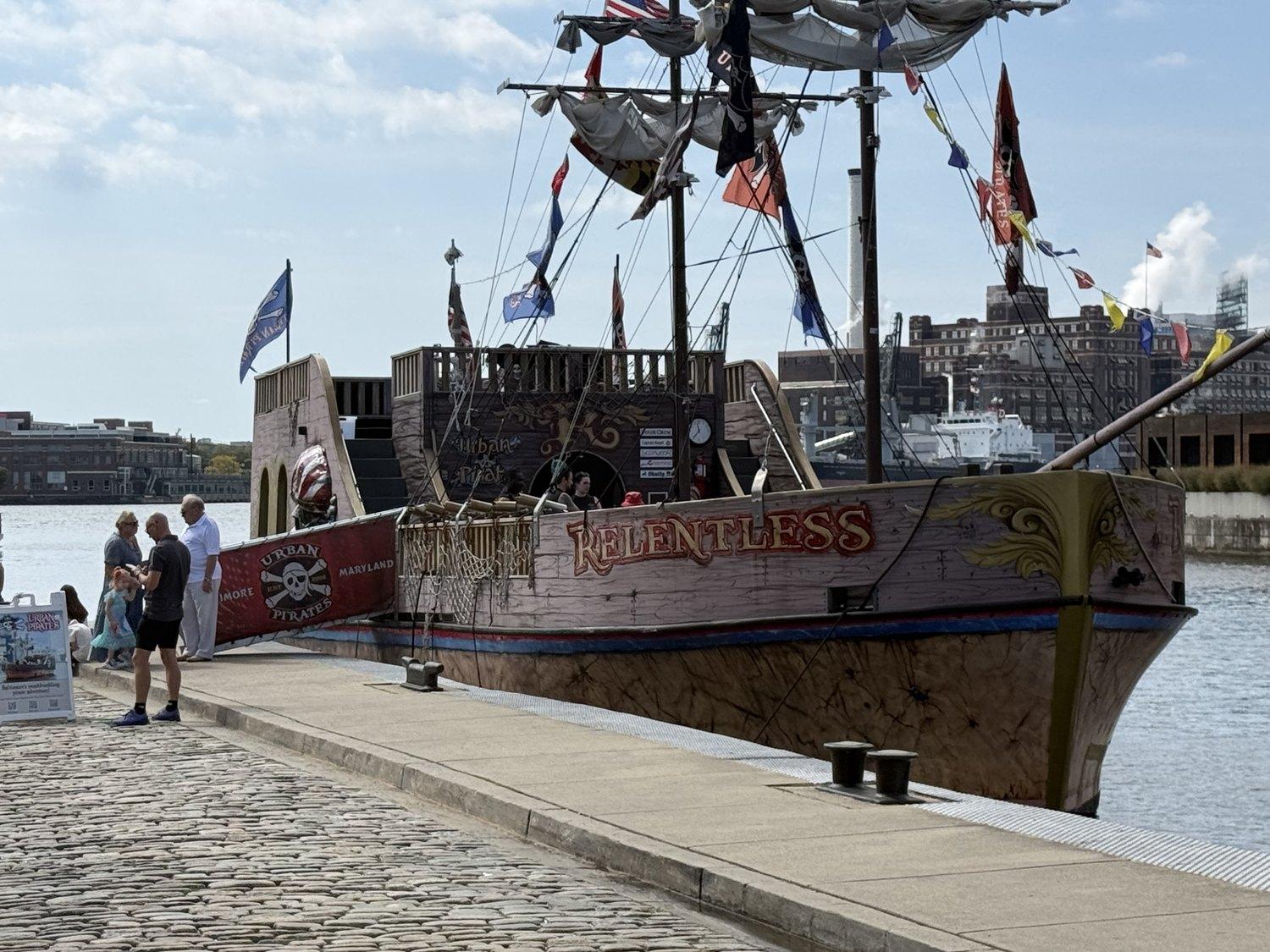 The pirate ship Relentless at her Fells Point berth, flags flying and the gangway down